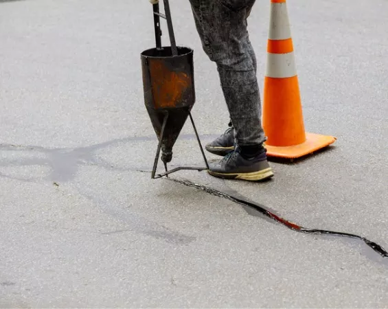 Crack repair being done before Asphalt sealcoating in Central Illinois