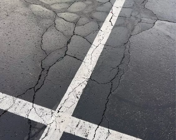 Cracked asphalt can be repaired with a simple asphalt sealcoating process from Hoerr’s Blacktop